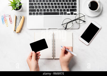 Une femme est en train de faire un achat en ligne, des maquettes et de carte de crédit sur téléphone cellulaire mobile office bureau isolé sur fond en mode copie, spac Banque D'Images
