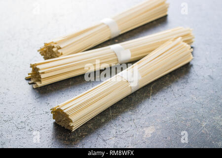 Nouilles udon brutes sur la vieille table de cuisine. Banque D'Images