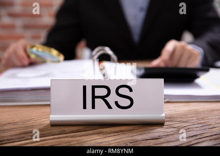 Avec la plaque signalétique sur le titre de l'IRS de bureau travaillant dans le bureau Banque D'Images