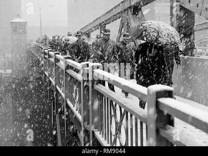 Les piétons traversent l'Etat rue pont sur la rivière Chicago, pendant une tempête,ca 1960. Banque D'Images