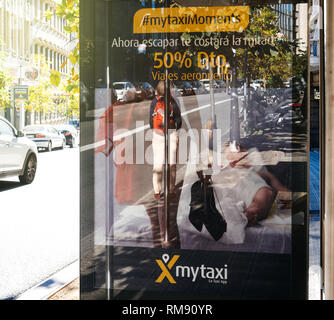 Barcelone, Espagne - Nov 12, 2017 : Reflet de femme femme d'attente des passagers pour le transport public de bus en gare avec MyTaxi application application application téléphone mobile publicité Banque D'Images