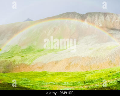 Dans une vallée de montagne arc-en-ciel, un arc-en-ciel naturel phénomène. Banque D'Images