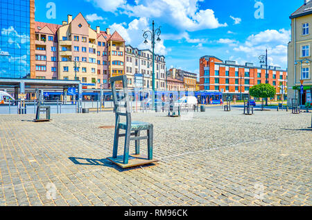 Cracovie, Pologne - 21 juin 2018 : Square des Héros du Ghetto avec des chaises vides de memorial victimes juives pendant la Seconde Guerre mondiale, la ville animée route avec traf rapide Banque D'Images