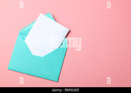 Enveloppe verte et lettre blanche sur fond rose. maquette Banque D'Images