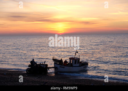 Hastings, East Sussex, UK. Feb 14, 2019. UK : Météo Hastings bateau de pêche en cours de lancement au lever du soleil. Hastings a la plus grande plage-lancé flotte de pêche en Europe. Credit : Carolyn Clarke/Alamy Live News Banque D'Images