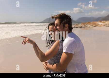 Vue latérale de la romantique happy young couple embracing on beach Banque D'Images