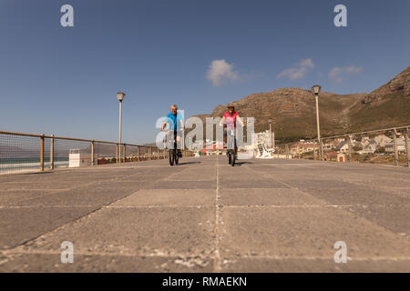 Couple de rouler à vélo sur une promenade à la plage Banque D'Images