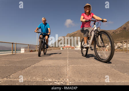 Couple de rouler à vélo sur une promenade à la plage Banque D'Images