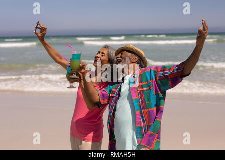 Woman with mobile phone selfies on beach Banque D'Images