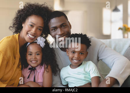 Happy African American family sitting on sofa and looking at Banque D'Images