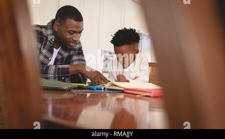 African American father aider son fils à faire ses devoirs à la table Banque D'Images