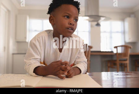 Thoughtful African American boy doing homework at table Banque D'Images