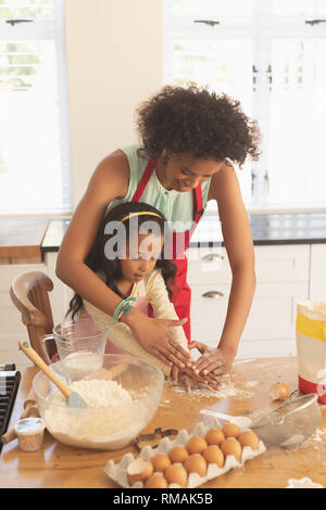 African American mother and daughter le pétrissage cookie dough in kitchen Banque D'Images