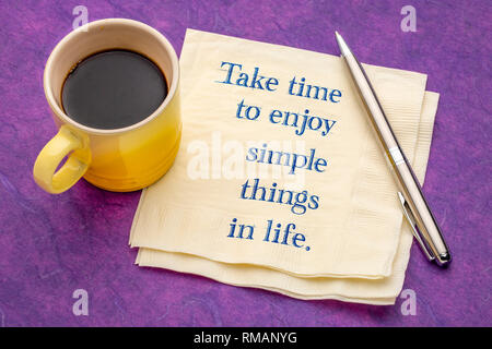 Prendre le temps de profiter des choses simples dans la vie de l'écriture - sur une serviette avec une tasse de café contre papier texturé coloré Banque D'Images