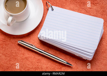 Une pile de cartes vierges avec une tasse de café et un stylo contre le papier d'écorce texturée Banque D'Images