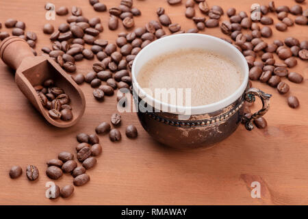 Le café dans une tasse vintage avec des grains de café et d'un scoop sur un fond de bois rustique foncé with copy space Banque D'Images