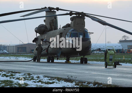 Un pilote américain, affecté à la 424e Escadron de la Base Aérienne, ravitailler l'armée américaine d'hélicoptères CH-47 Chinook de la 1re Brigade d'aviation de combat, 1re Division d'infanterie, sur la base aérienne de Chièvres, Belgique, le 30 janvier 2019. La Base Aérienne de Chièvres a servi comme une zone d'étape intermédiaire avant la 1re Brigade d'aviation de combat se déploie à l'Allemagne, la Pologne, la Lettonie et la Roumanie pendant neuf mois pour former avec les partenaires de l'OTAN à l'appui de la résolution de l'Atlantique. (U.S. Photo de l'armée par Visual Spécialiste de l'information Pascal Demeuldre) Banque D'Images