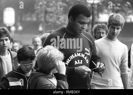 L'ancien champion du monde de boxe américaine Championne olympique et Muhammad Ali donne à ses jeunes fans des autographes. Banque D'Images