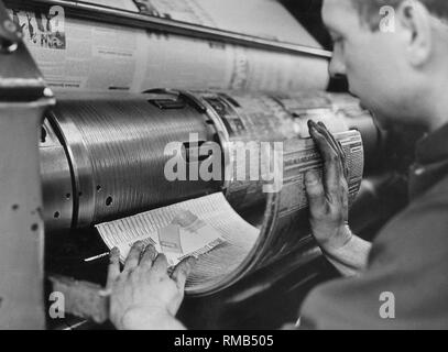 Une imprimante met une plaque d'impression semi-circulaire sur une machine d'impression rotative sans date (photo). Banque D'Images