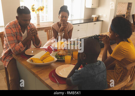 African American family priant ensemble à table à manger Banque D'Images