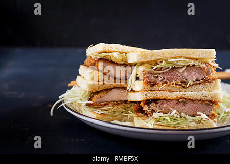 Katsu Sando - tendance alimentaire sandwich japonais avec côtelette de porc panée, le chou et la sauce tonkatsu. La cuisine japonaise. Banque D'Images