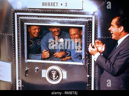 Président des États-Unis Richard Nixon en conversation avec les astronautes de la mission Apollo-11-, Neil A. Armstrong, Michael Collins et Edwin Aldrin dans le navire de récupération U.S.S. Hornet. Après leur retour sur terre, les astronautes doivent être mis en quarantaine pour trois semaines. Banque D'Images