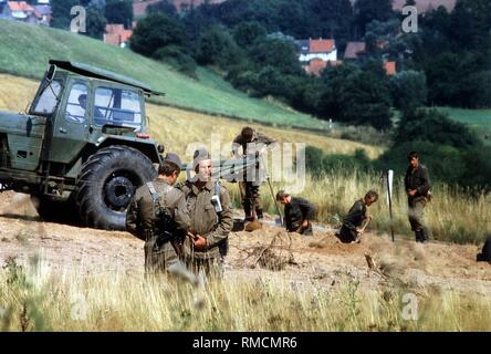 Les membres de la troupes frontalières de la RDA regarder les travaux d'extension de la frontière installations Eichsfeld. Banque D'Images