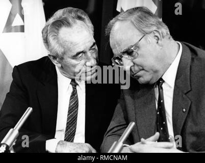 Le Premier ministre israélien Shimon Peres et l'Ouest chancelier allemand Helmut Kohl en conversation. Probablement au cours d'une conférence de presse. Banque D'Images