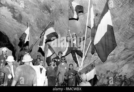 Le 14 août 1962 la percée du Mont-Blanc-Tunnel a été réalisée à l'aide d'une démolition dernière. Dans leur enthousiasme, les travailleurs d'encouragement l'onde drapeaux nationaux. Le tunnel du Mont-Blanc est de 11,6 kilomètres de long et relie la ville thermale de Chamonix-Mont-Blanc avec l'Italien Courmeyeur et la vallée d'Aoste. Photo : amw Banque D'Images