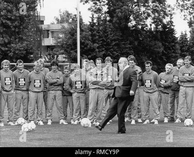 Le chancelier allemand Helmut Kohl (milieu) kicks a football lors de sa visite du camp d'entraînement à Kaiserau, où l'équipe nationale allemande séjours. Banque D'Images