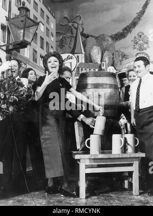 Caterina Valente, une actrice allemande et artiste du spectacle, touchant la bière forte. Banque D'Images