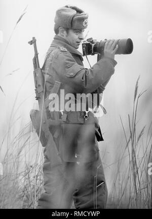 Un soldat de l'Armée Nationale Populaire avec une caméra sur la frontière près de Buestedt, dans le district de Helmstedt. Banque D'Images