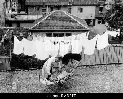 Un enfant se trouve dans le soleil sur le toit-terrasse d'une ancienne maison de ville à Lindau. Banque D'Images