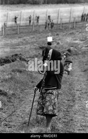 Une vieille femme regarde de la territoire fédéral allemand pour le travail sur le renforcement de la frontière près de Fuhrbach. Banque D'Images