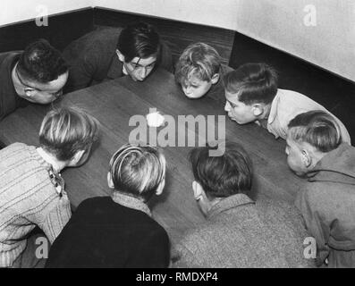 Enfants soufflant des boules de coton, 50s Banque D'Images
