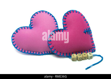 Textile cousu main avec coeurs mot amour sur des cales filetées sur cordes isolé sur fond blanc pour une relation romantique, Saint Valentin, Brok Banque D'Images
