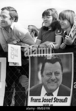 Cette photo montre une famille, équipé de divers accessoires promotionnels de l'élection, dans l'auditoire lors d'une élection, cas de l'Union européenne. Sur la barrière se bloque une affiche qui annonce l'apparition de la candidat de chancelier de l'Union, CSU, Franz Josef Strauss. Banque D'Images