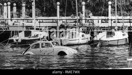 Une VW Beetle flottant en face de la jetée d'atterrissage dans la marina de Torbole sur le lac de Garde. Banque D'Images