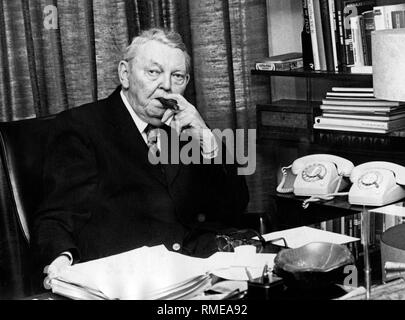 Portrait de l'ancien Chancelier Ludwig Erhard sur son 80e anniversaire à son bureau, fumer un cigare. Banque D'Images