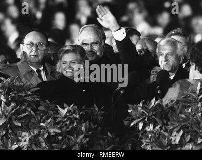 Le chancelier allemand Helmut Kohl (milieu) brandit à la population à Berlin le premier jour de congé officiel de la réunification allemande. Sur le côté gauche vous pouvez voir sa femme Hannelore, alors ministre d'état des affaires étrangères Hans-Dietrich Genscher, sur le côté droit, il y a Richard von Weizsäcker. Banque D'Images