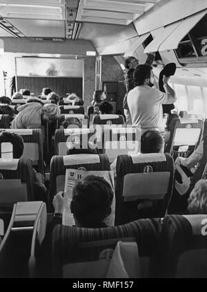 Vue de l'intérieur d'un avion Lockheed L-1011 Tristar de LTU airline juste avant de décoller à Duesseldorf. Les passagers sont occupés à leurs bagages dans la cabine. Banque D'Images