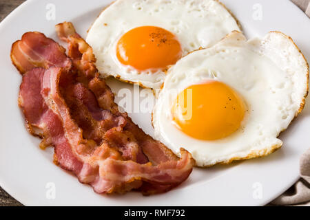 D'œufs au plat et du bacon pour le petit déjeuner sur la table en bois. Close up Banque D'Images