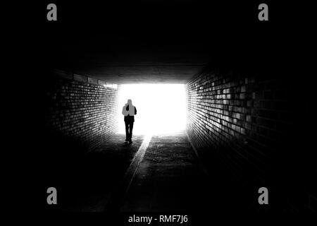 Un homme qui marchait dans un tunnel noir Banque D'Images