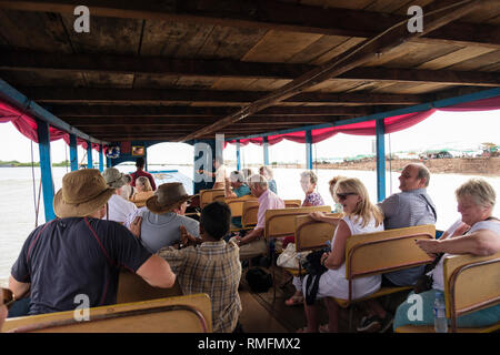 Les touristes occidentaux de partir en excursion en bateau traditionnel pour Kampong Phluk guindé village flottant dans le lac Tonle Sap. La province de Siem Reap, Cambodge Banque D'Images