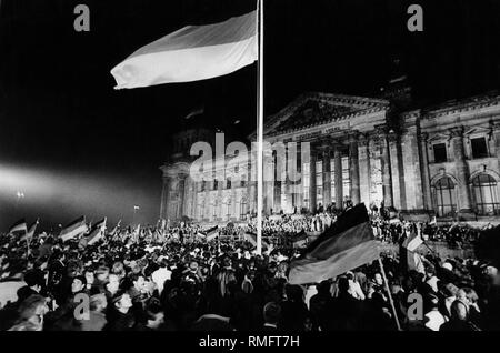 Levage de personnes drapeaux allemands pendant la célébration à l'occasion de la réunification allemande, avant que le Reichstag allemand. Regroupement familial : nuit du 02.10.1990-03.10,1990 à Berlin, la politique, l'Allemagne, République fédérale de 1990 Banque D'Images