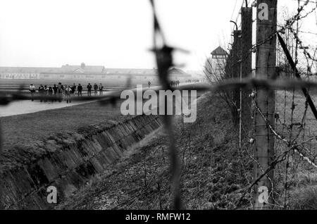 L'image a été prise en 1984 d'une visite de l'emplacement de l'ancien camp de concentration de Dachau. Droit, barbelés, dans l'arrière-plan une ancienne tour de guet et quitté le bâtiment de ferme. Banque D'Images