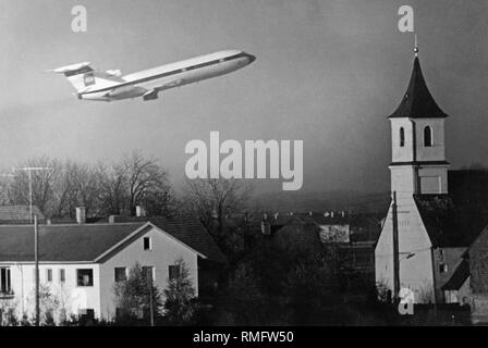 Peu après le décollage à l'aéroport de Munich à Riem, un avion du passager vole au-dessus de la communauté de Haar, près de Munich. Photo non datée, probablement au début des années 70. Banque D'Images