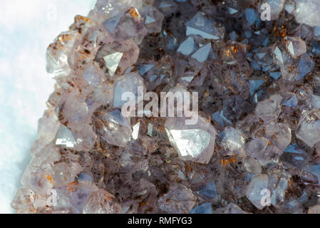 Améthyste cristal naturel cluster avec inclusions de goethite du Brésil sur la neige blanche à un jour d'hiver ensoleillé. Banque D'Images