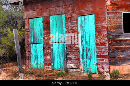 Portes de grange triple forme turquoise peint l'avant de cette grange rustique dans le Nouveau Mexique. Lui-même est une grange rouge rustique avec peeling et peinture craquelée. Banque D'Images