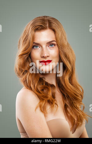 Tête rouge élégante femme. Fille aux cheveux rouge parfait avec de longs cheveux bouclés hairstyle portrait Banque D'Images